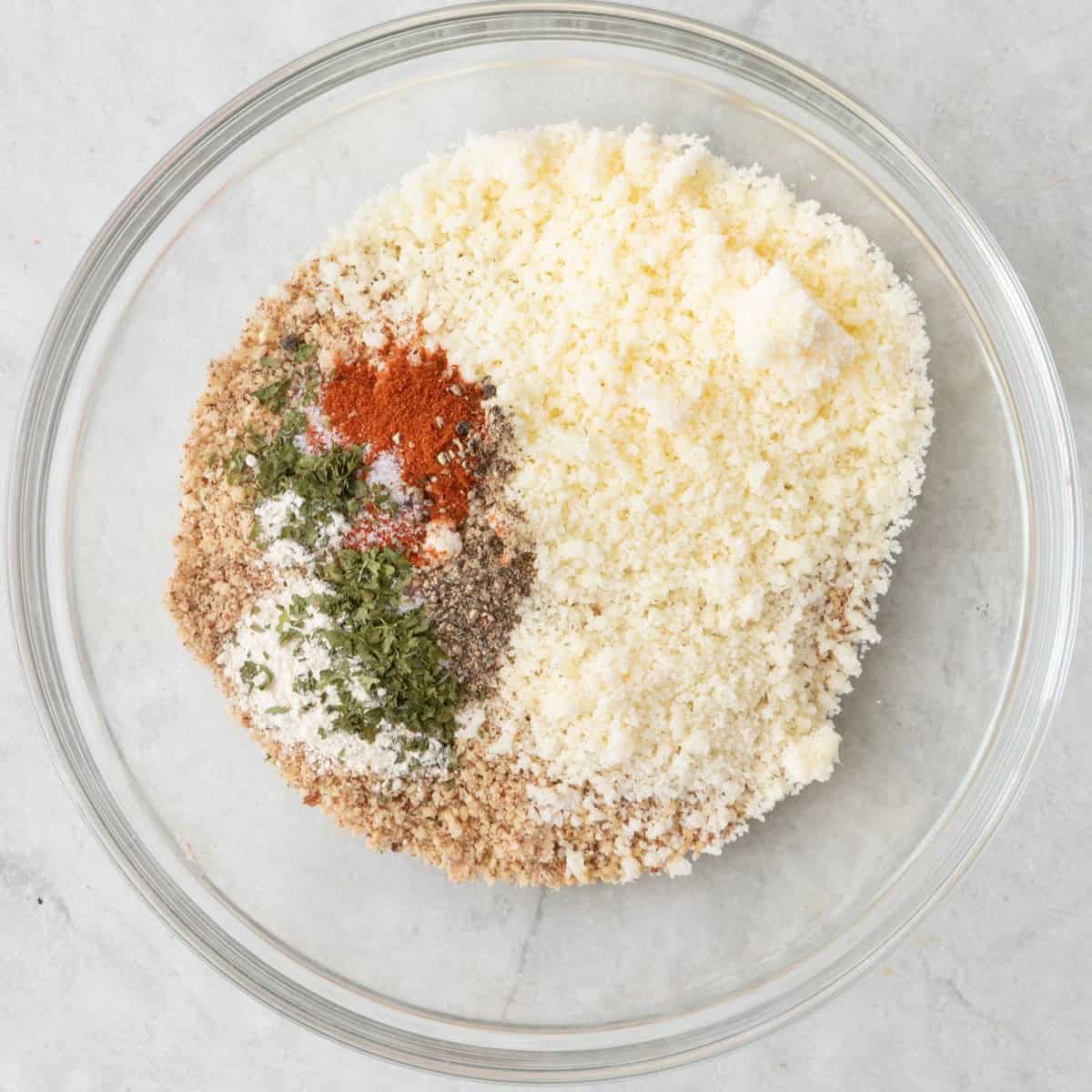 Almond crumbs, parmesan cheese and seasonings in a mixing bowl before combining.