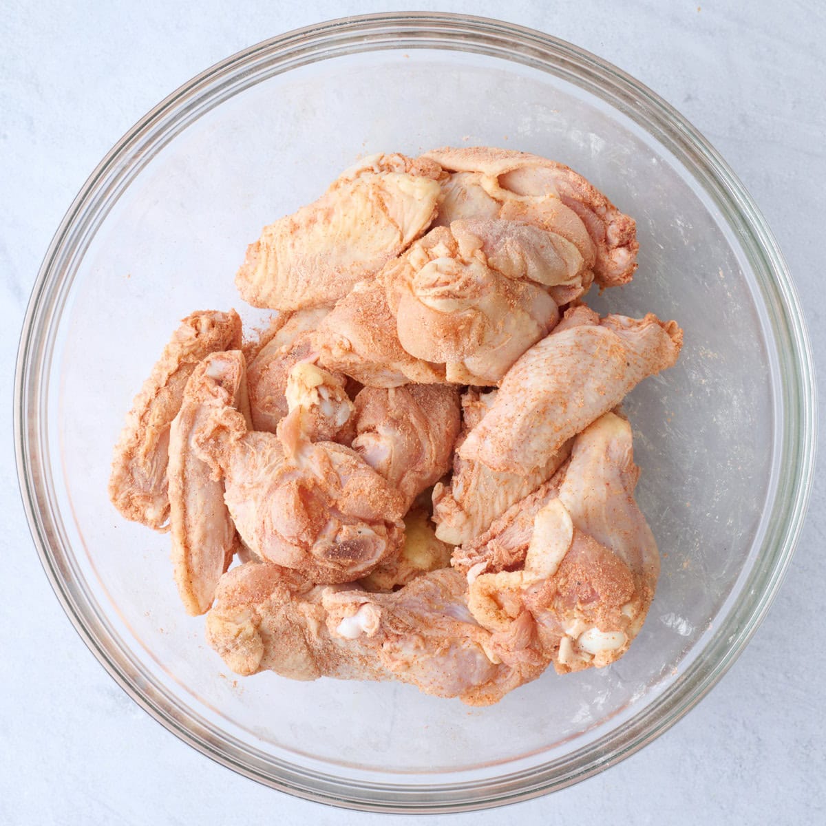 Wings tossed in a seasonings blend with baking powder until fully coated.