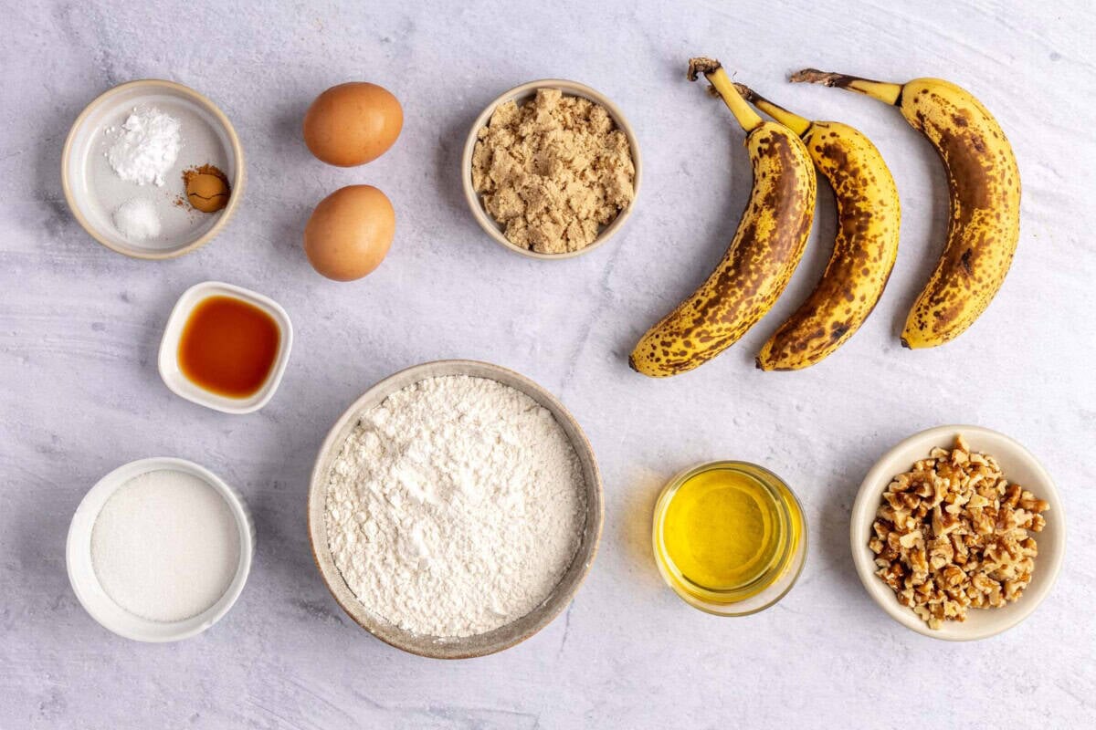 Ingredients for muffin recipe: bananas, walnut, oil, flour, brown sugar, eggs, vanilla, sugar, salt, cinnamon, and baking powder.
