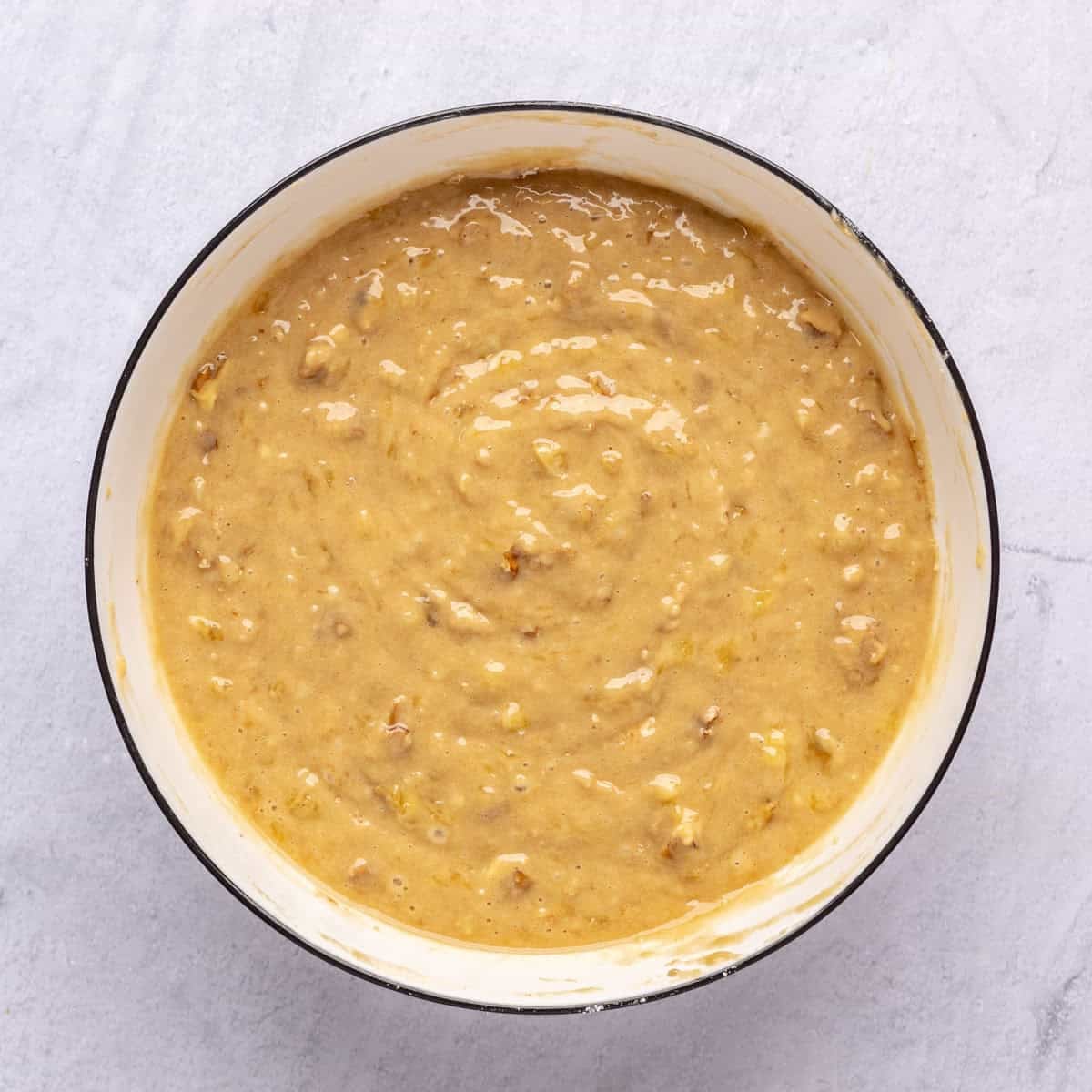 Final muffin batter with nuts and bananas in a bowl.