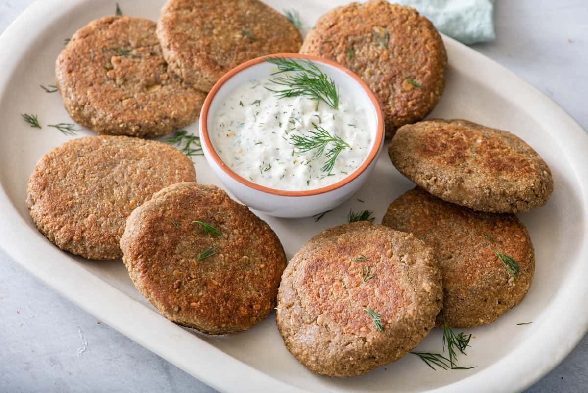 Easy lentil cakes recipe served on a platter with dip.