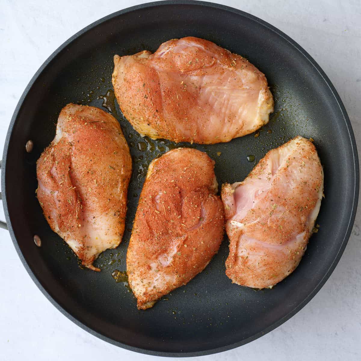 Seasoned chicken breast in a skillet .