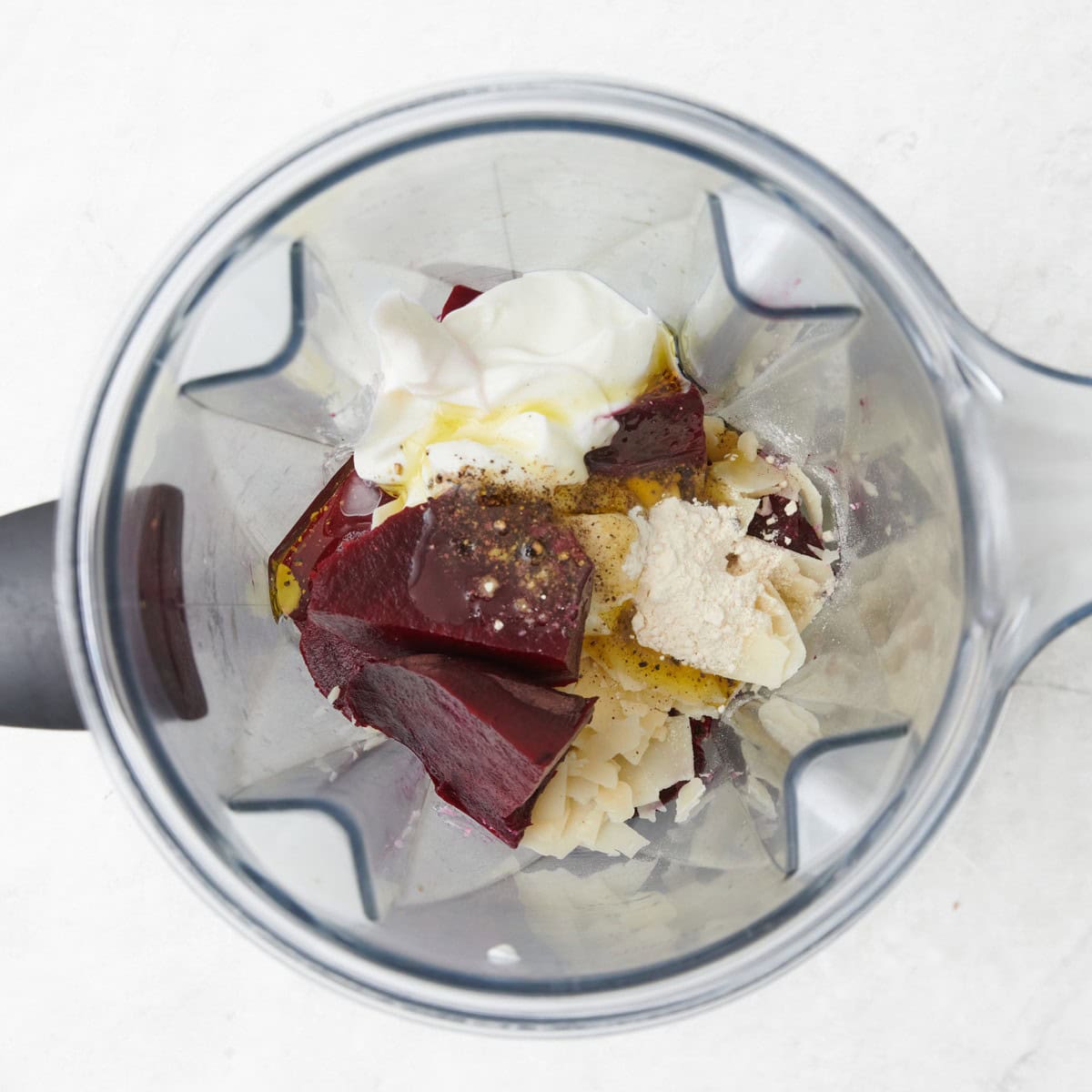 Roasted beets, yogurt, and other sauce ingredients in a blender before blending.
