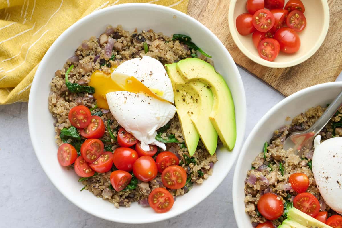 Best quinoa breakfast power bowl with mushroom and spinach quinoa, poached egg, avocado and tomatoes.