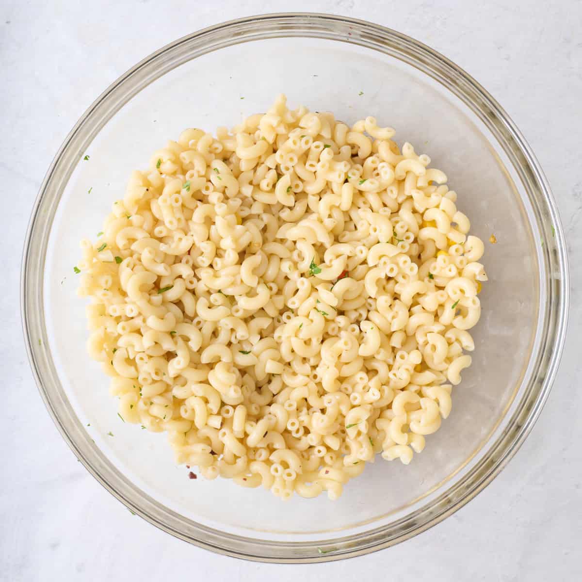 Cooked pasta added on top of dressing before tossing together.