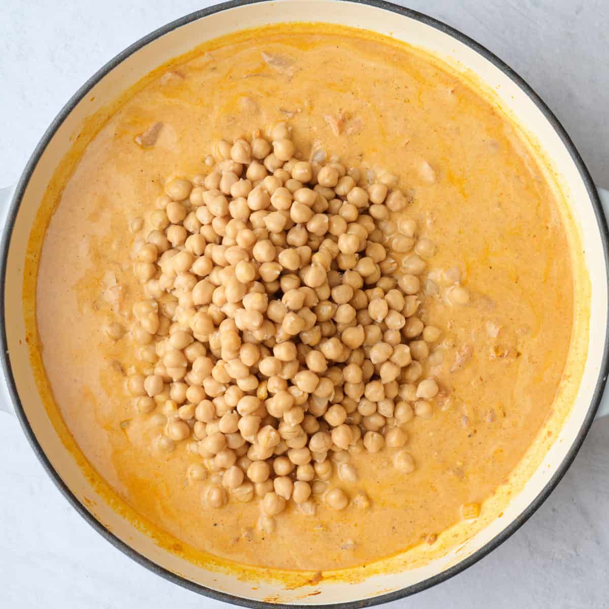Chickpeas poured into the skillet, before combining.