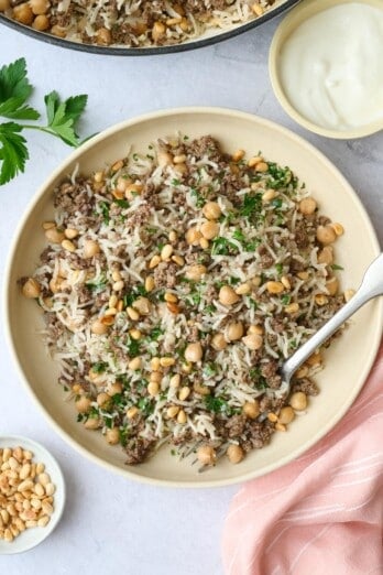 Best ground beef and rice recipe made with Middle eastern spiced and topped with toasted pine nuts and parsley with a side of yogurt for serving.