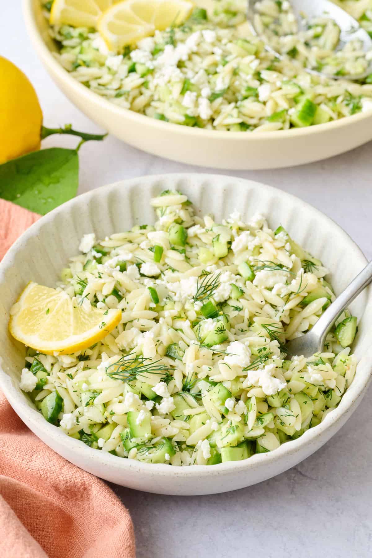 Best lemon orzo soup with cucumbers served in a bowl with fresh dill and lemon.