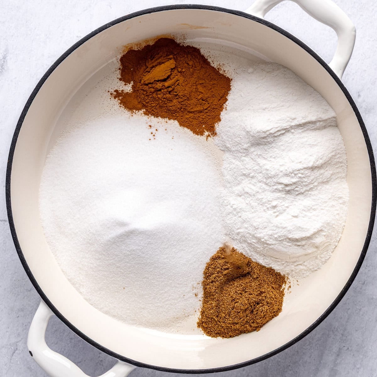 Sugar, rice flour, cinnamon and caraway in a large pot before whisking them together.