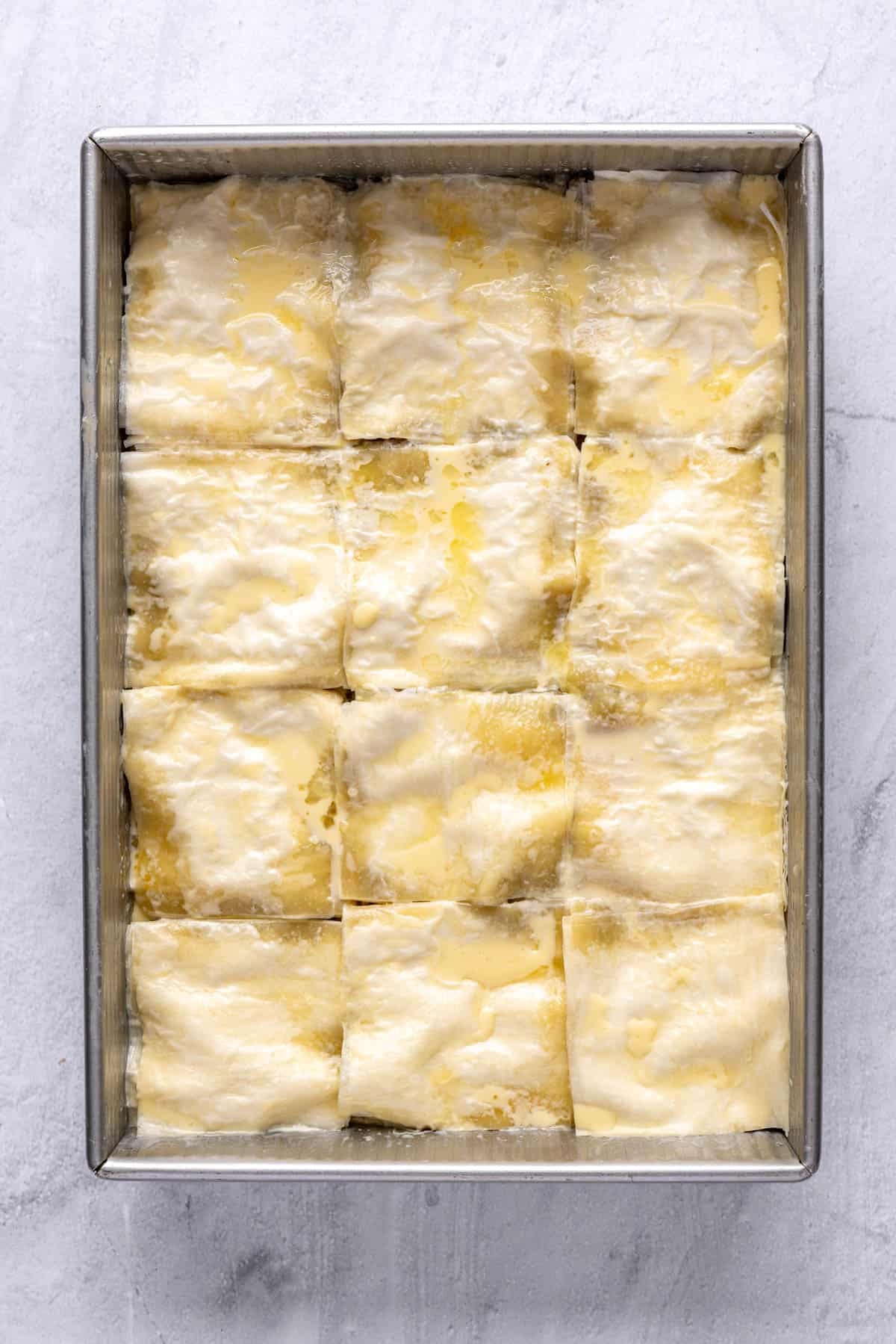 The meat pie after the butter has soaked into the phyllo, with the egg mixture poured over it.