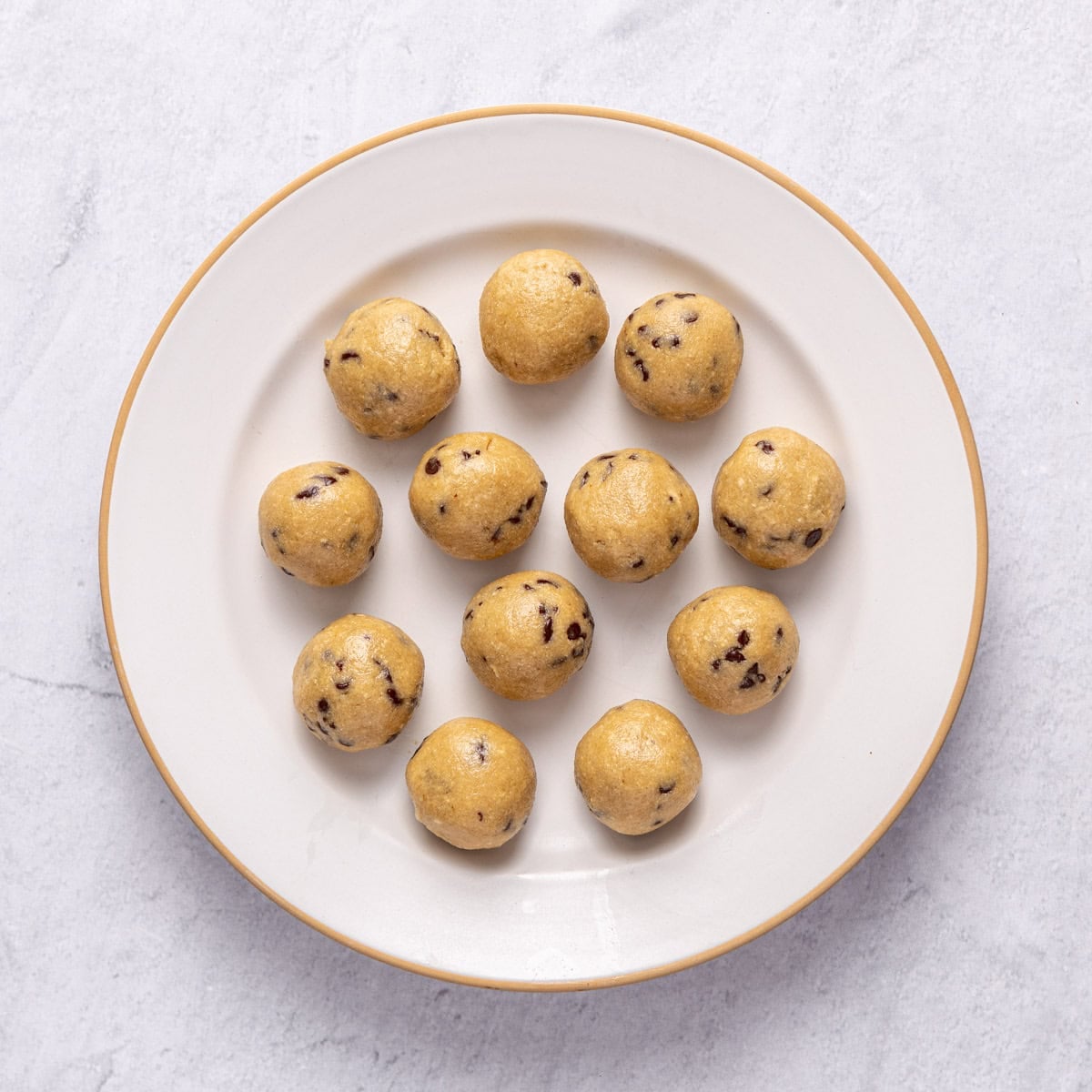 Chocolate chip protein balls shaped into balls on a plate.