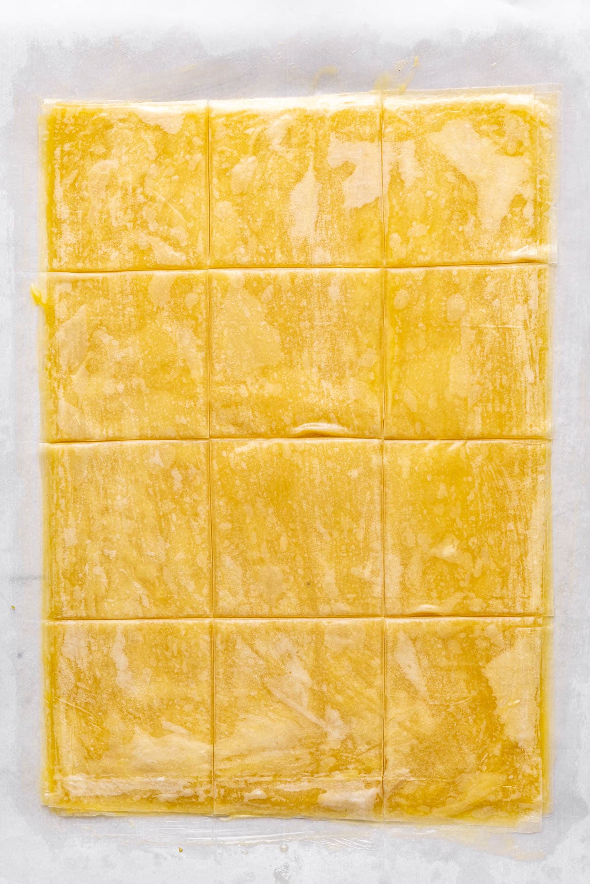All of the phyllo sheets after they are brushed with butter and cut into squares.
