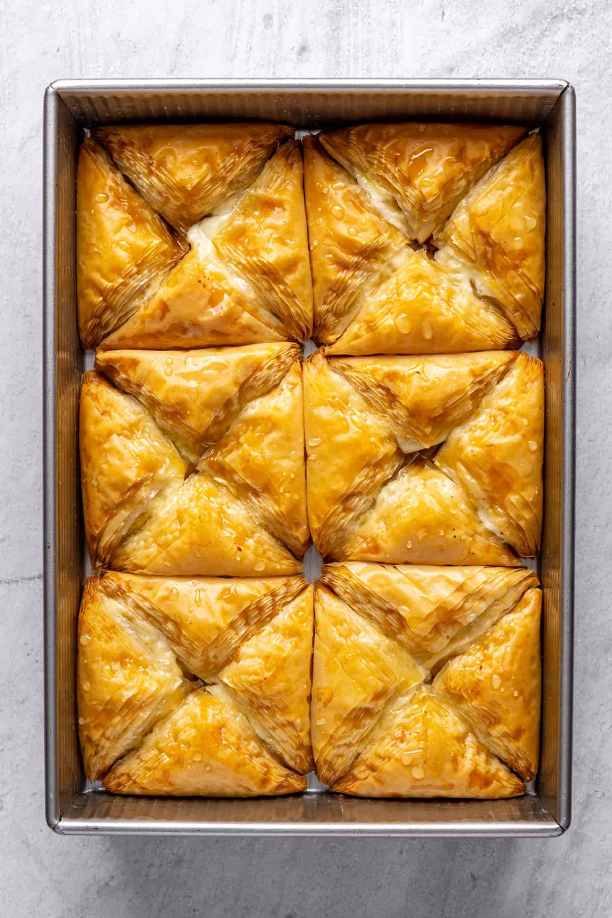 Shaabiyat in a baking dish after removing it from the oven and pouring simple syrup over it.