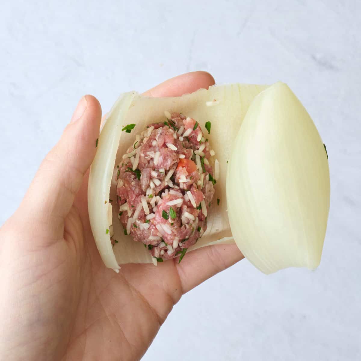 Softened onion layer filled with ground beef and rice mixture.