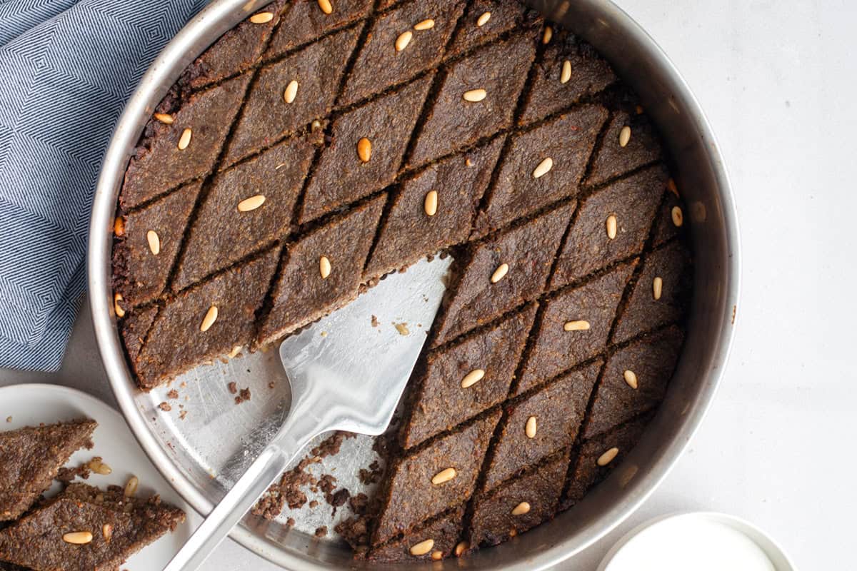 Lebanese kibbeh recipe made with ground beef after baking with a serving spatula inside pan.