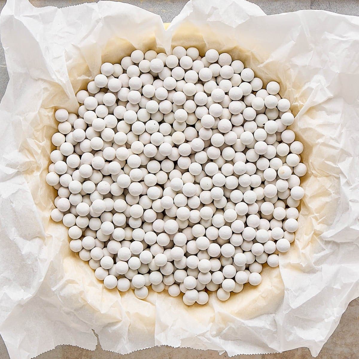 Parchment paper added with pie weights before baking.