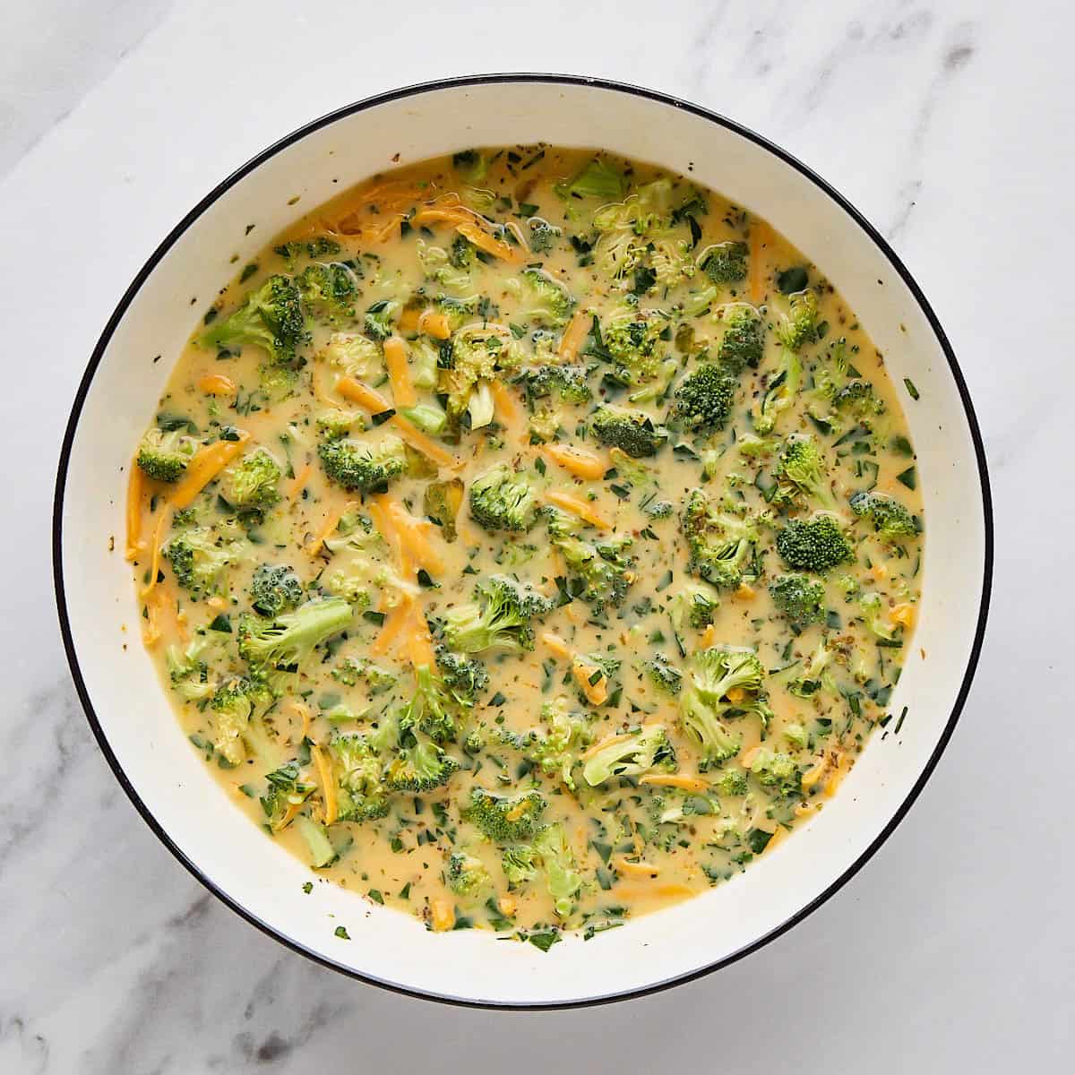 Egg mixture with broccoli and cheese for quiche after combining.
