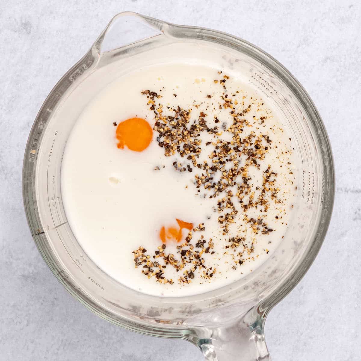 Eggs, milk and seasonings in a measure cup before whisking.