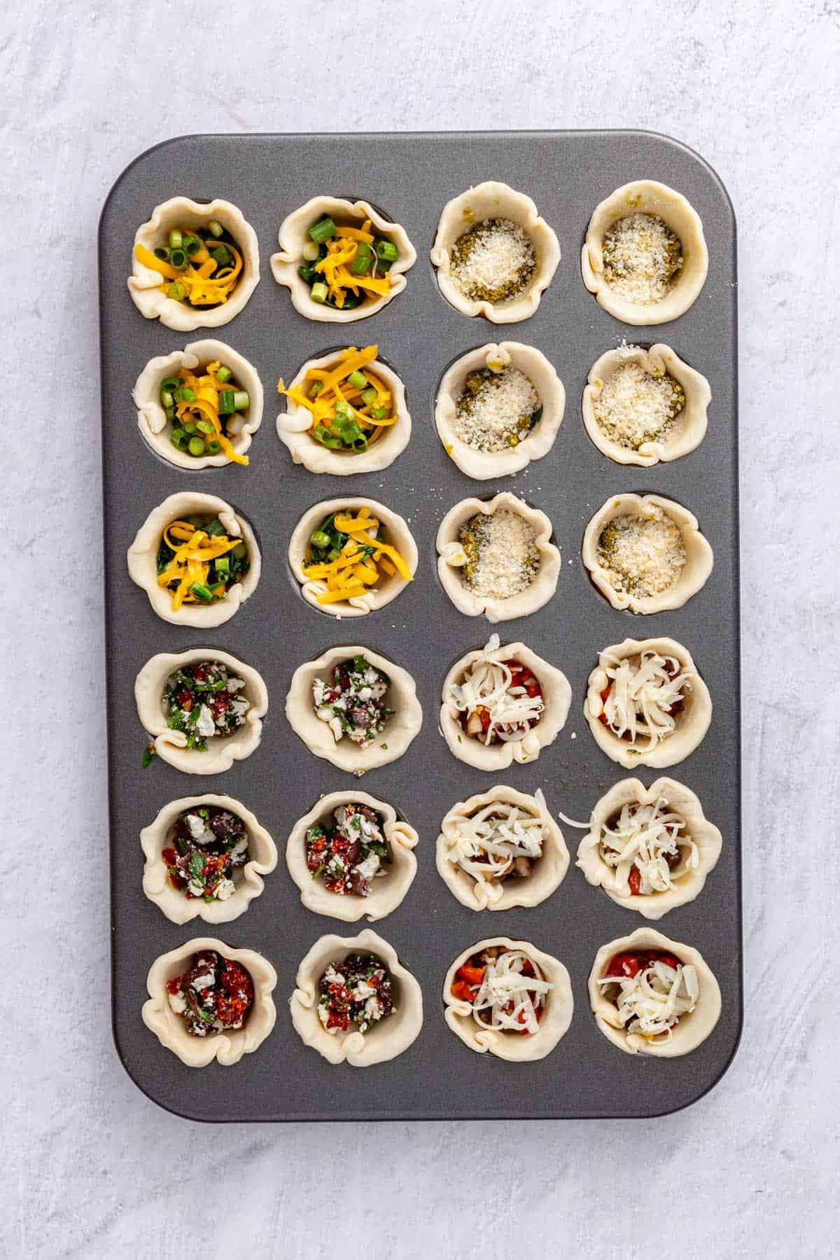 A mini muffin pan with each round pressed into each slot, and filling added to each.