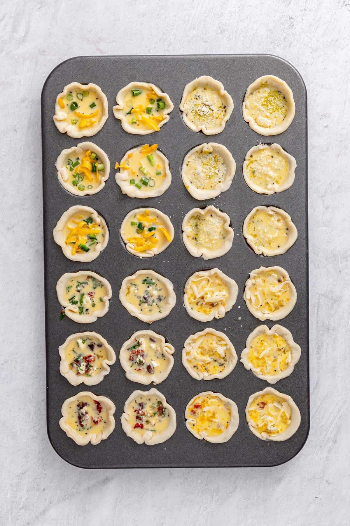 A mini muffin pan with egg added to make fully filled slots.