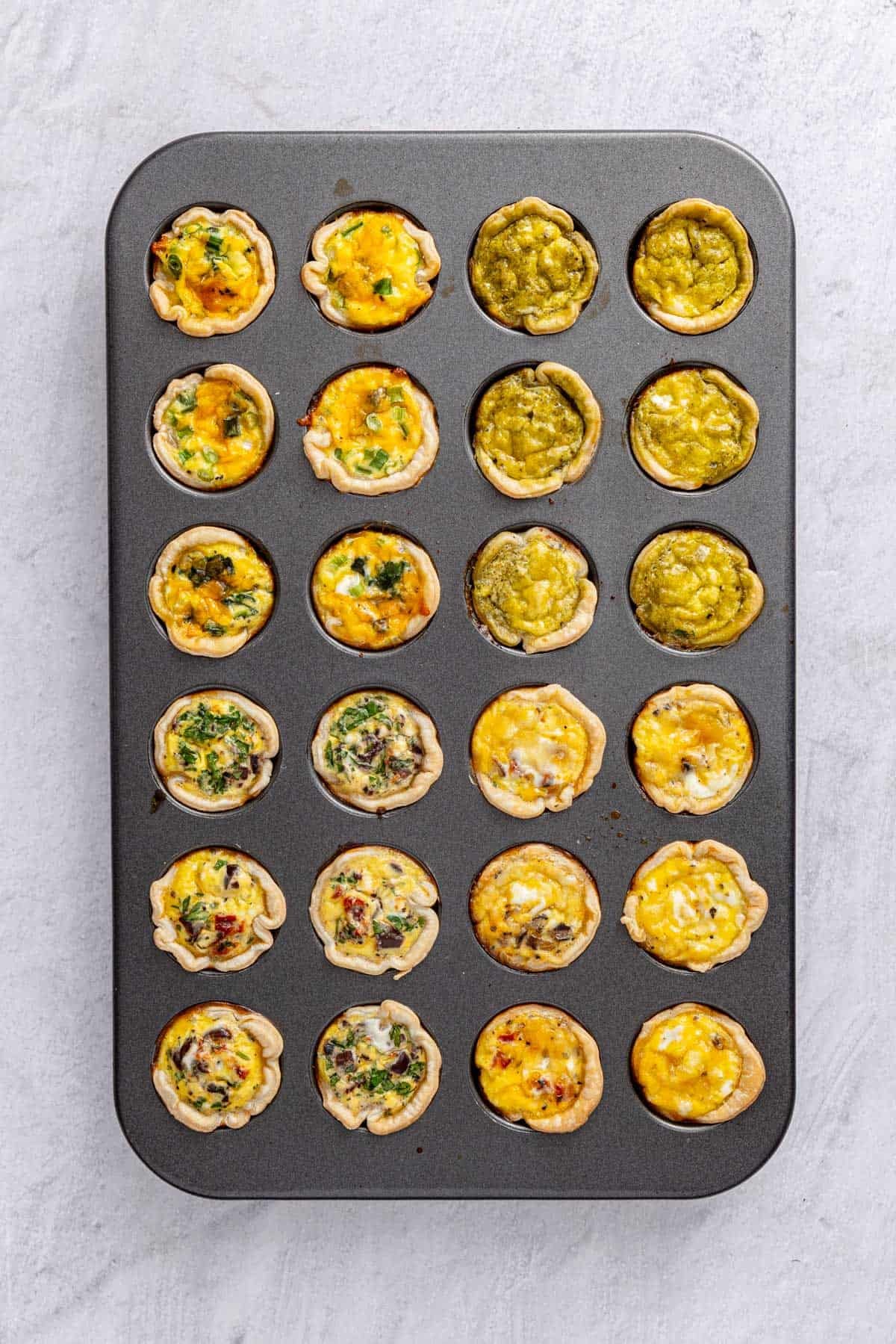 A mini muffin pan with cooked mini quiche after removed from the oven.