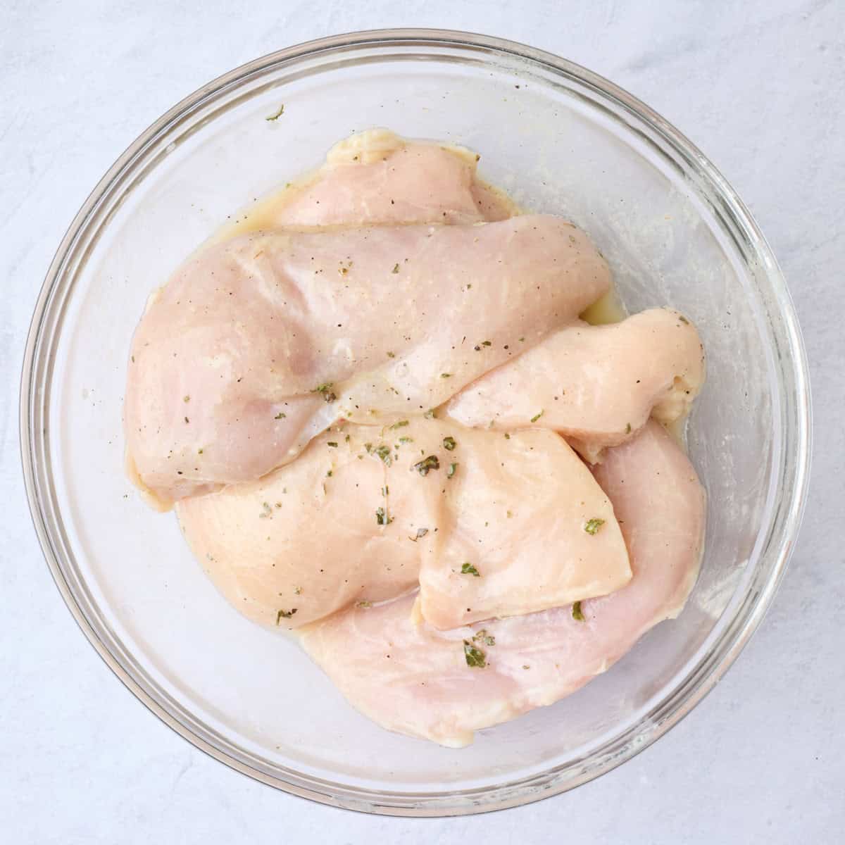 Chicken in a large bowl tossed in โ
cup of dressing.