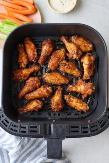 Best air fryer chicken wings in the basket after cooking until crispy.