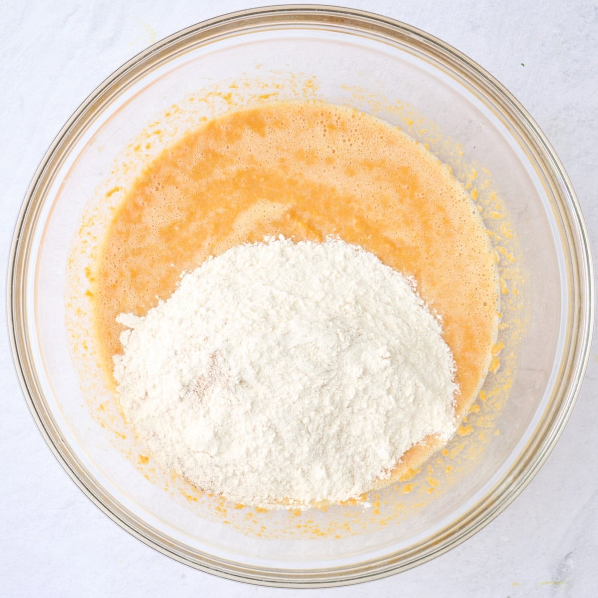 Dry ingredients added on top of wet ingredients for waffle batter.
