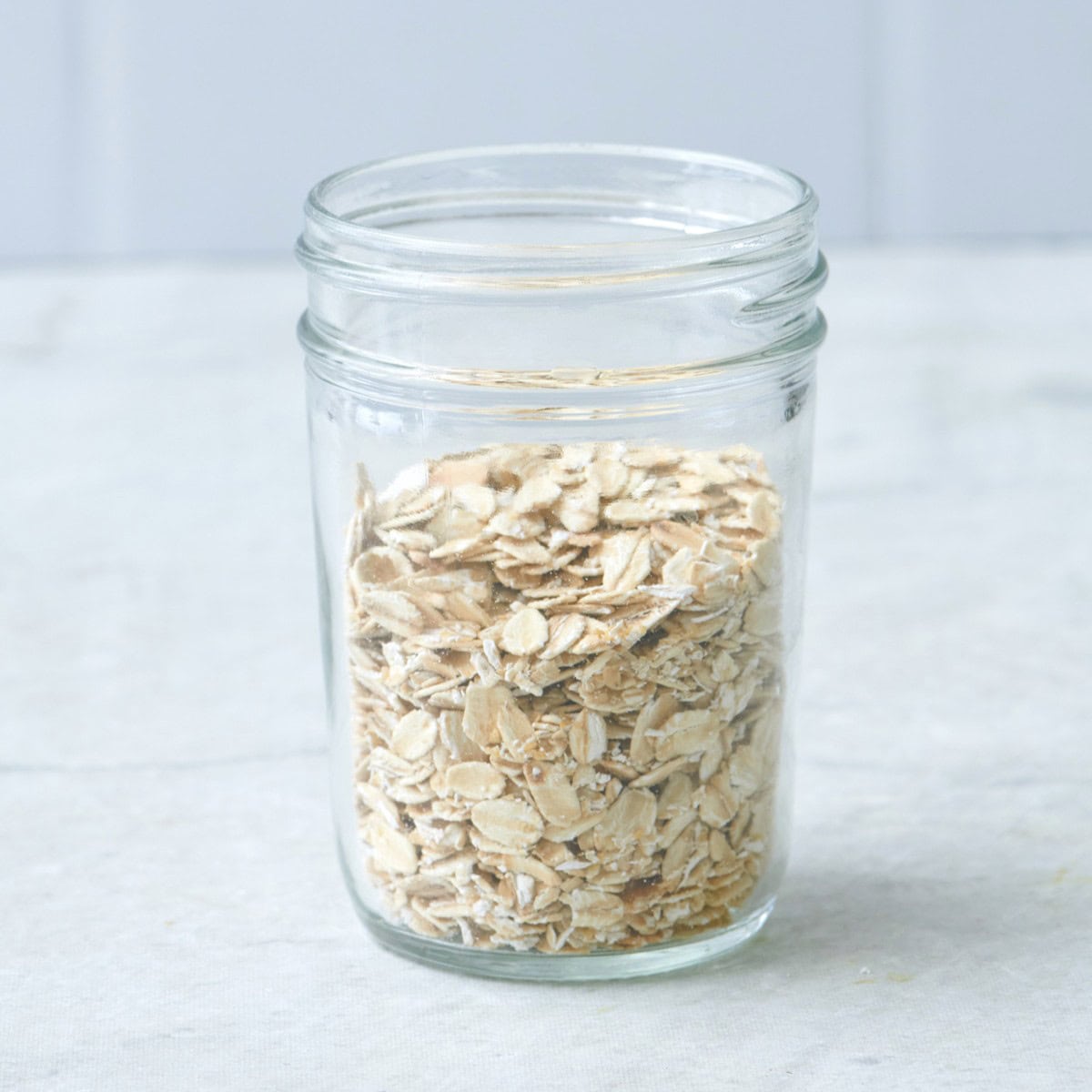 Rolled oats in a small glass jar.